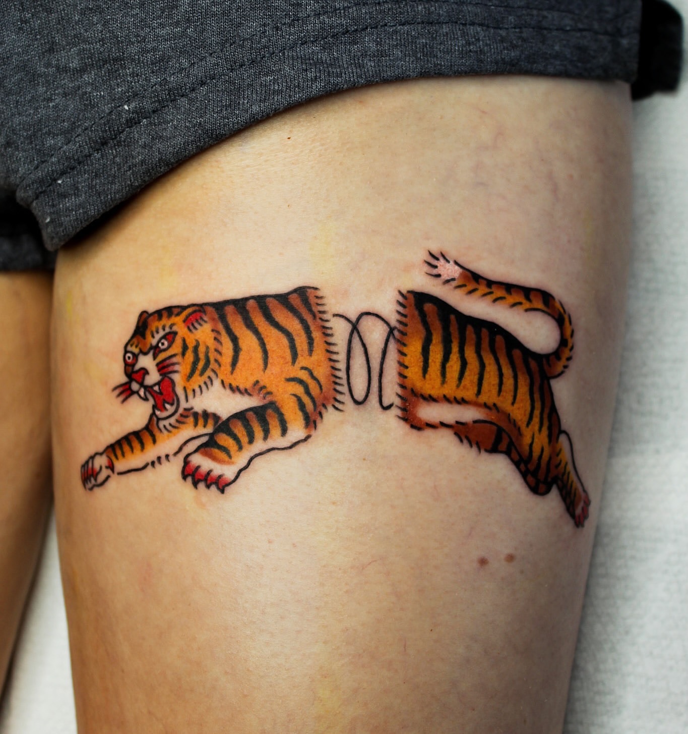 Tiger American traditional tattoo on the thigh by Kehrmie Tattoos, Berkeley, California