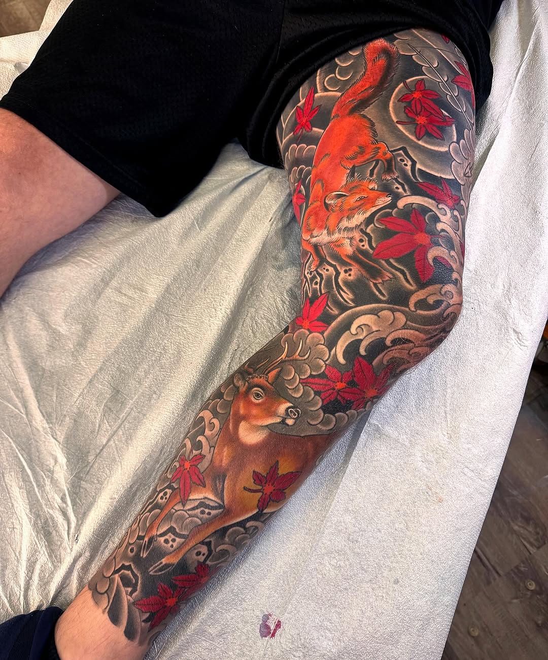 Fox and deer with maple leaves Japanese tattoo on the forearm by Erick Lynch, Cambridge, Massachusetts