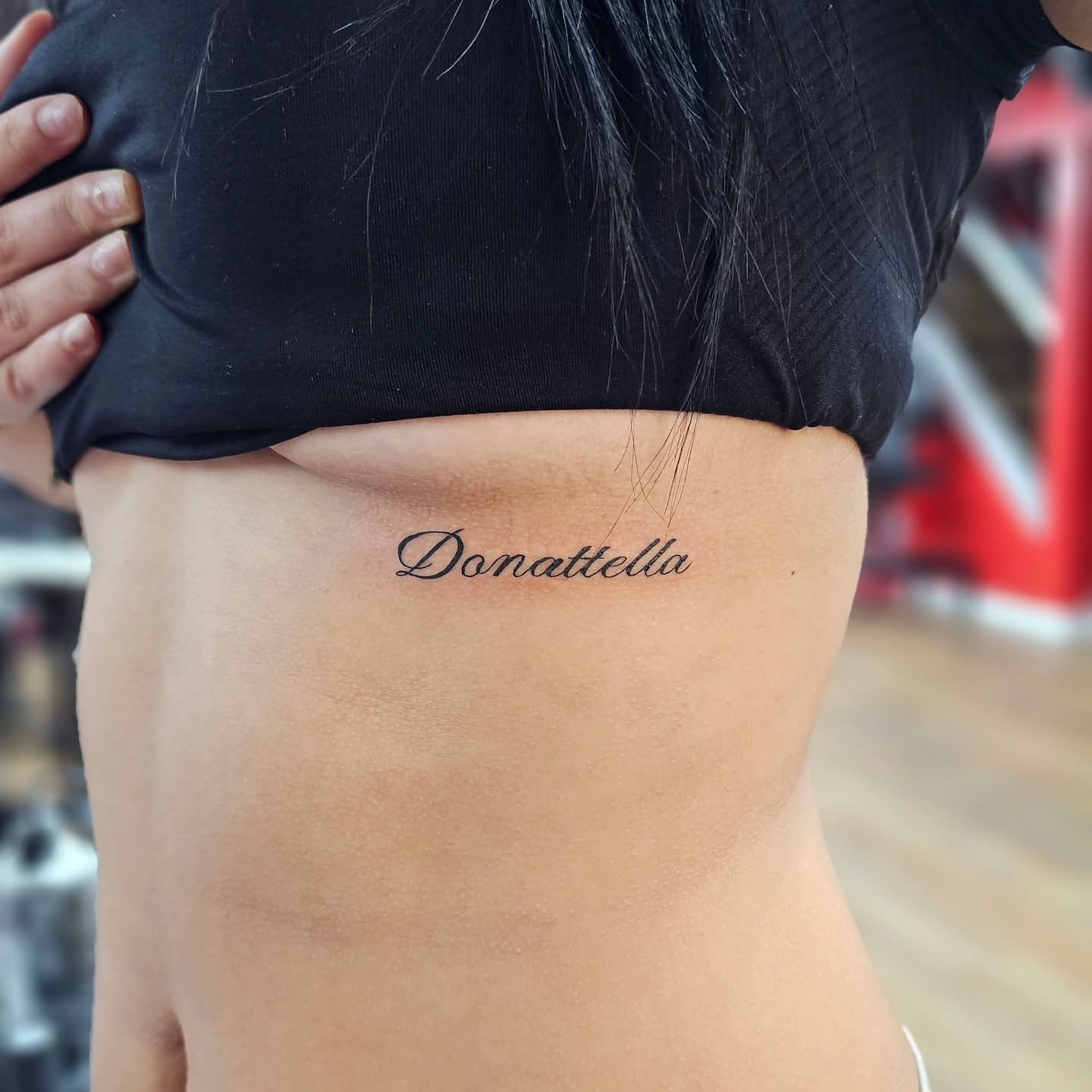 Donattella lettering script tattoo on the ribs by John Briceño, Columbus, Ohio