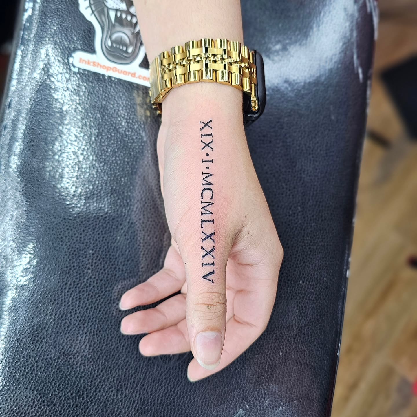 Roman numerals lettering script tattoo on the hand by John Briceño, Columbus, Ohio
