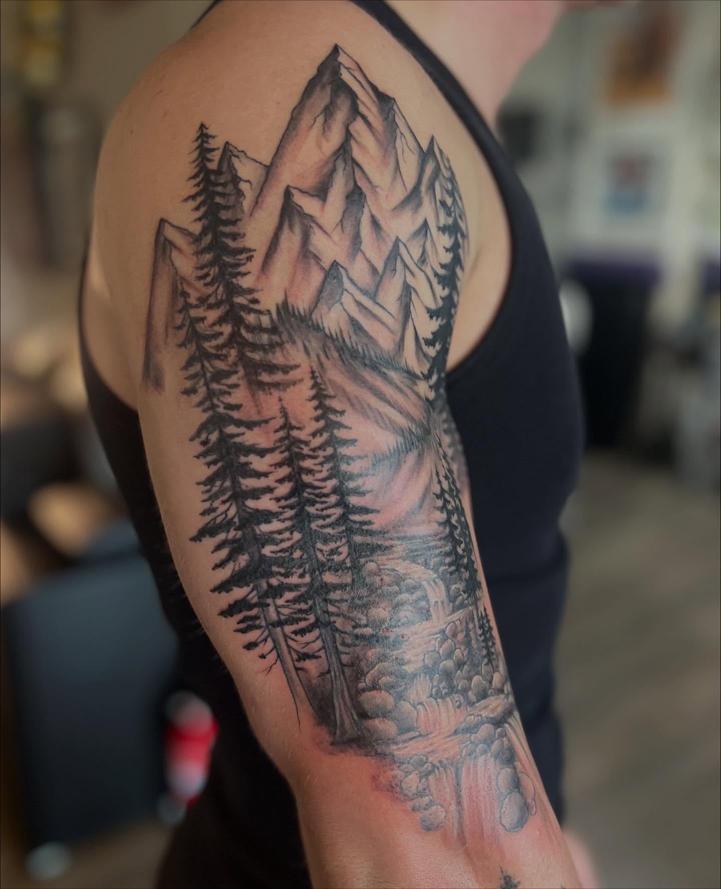 Mountain landscape realism tattoo on the forearm by Rikki