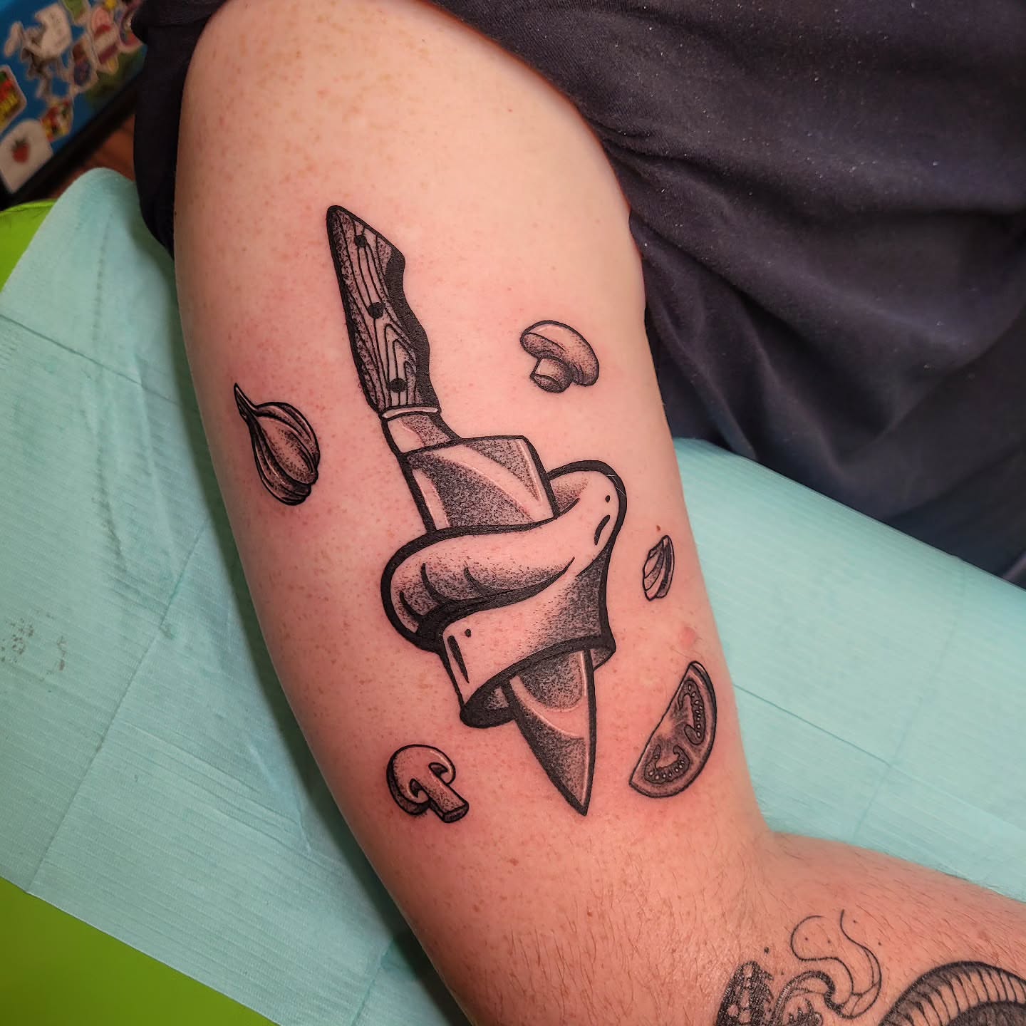 Knife and food black and grey tattoo on the thigh by Wray Saulsberry