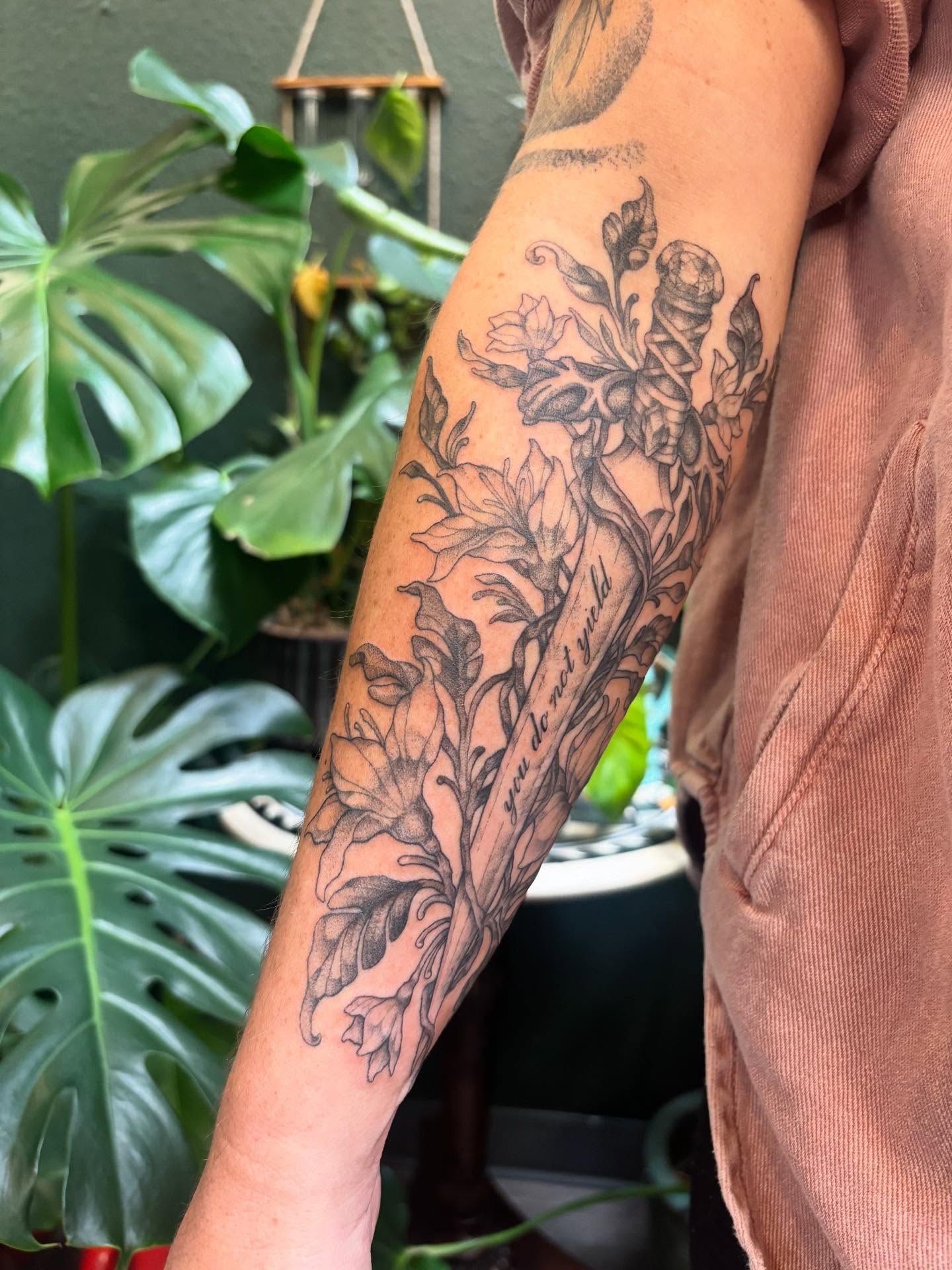 Floral arrangement black and grey tattoo on the forearm by Rachel Foster