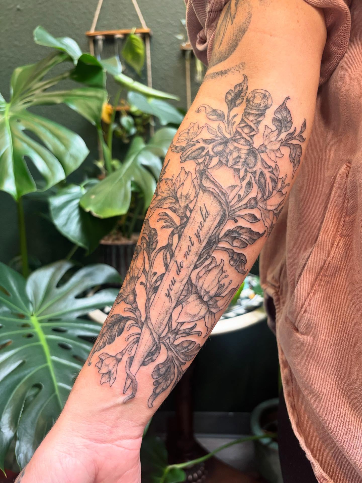 Floral arrangement black and grey tattoo on the forearm by Rachel Foster
