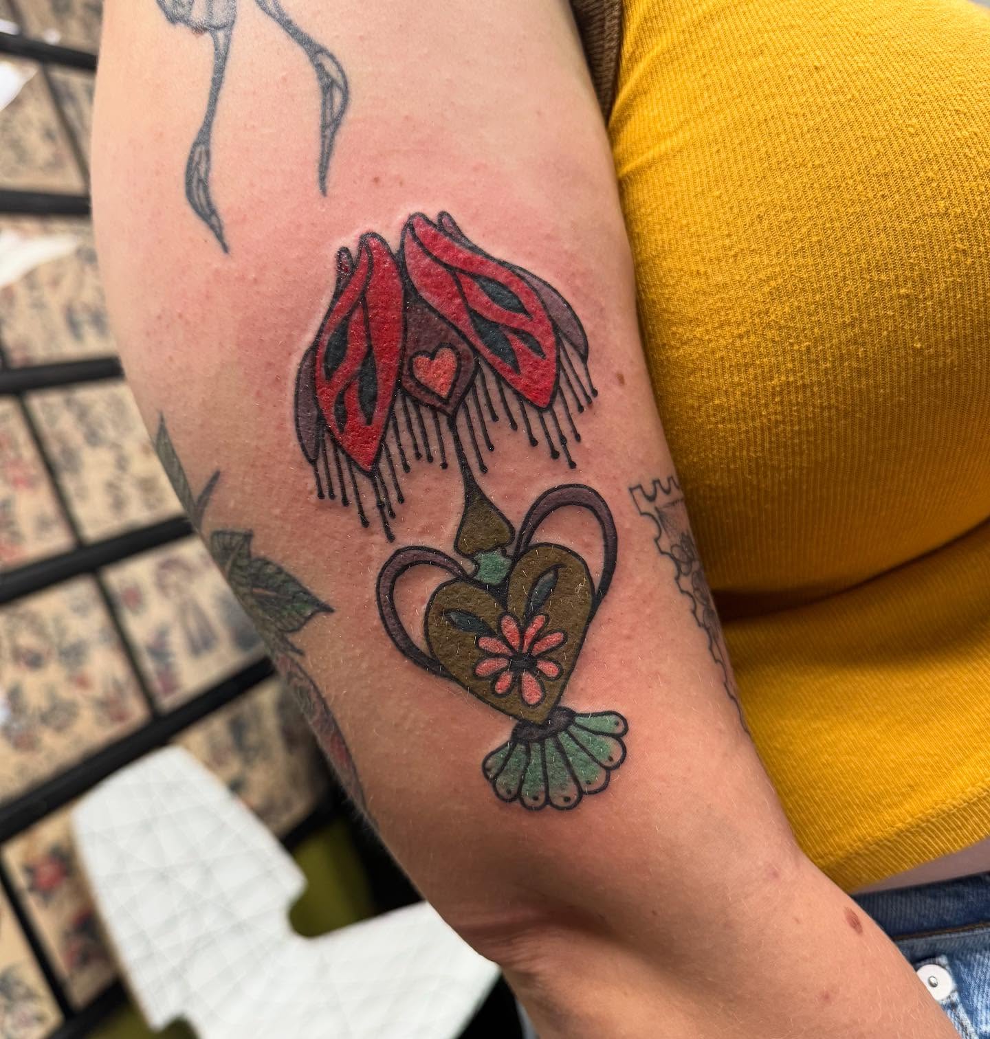 Fuchsia flowers and heart American traditional tattoo on the forearm by 𝗞𝗮𝘁 𝗕𝗹𝗮𝗻𝗸𝗲𝗻𝘀𝗵𝗶𝗽