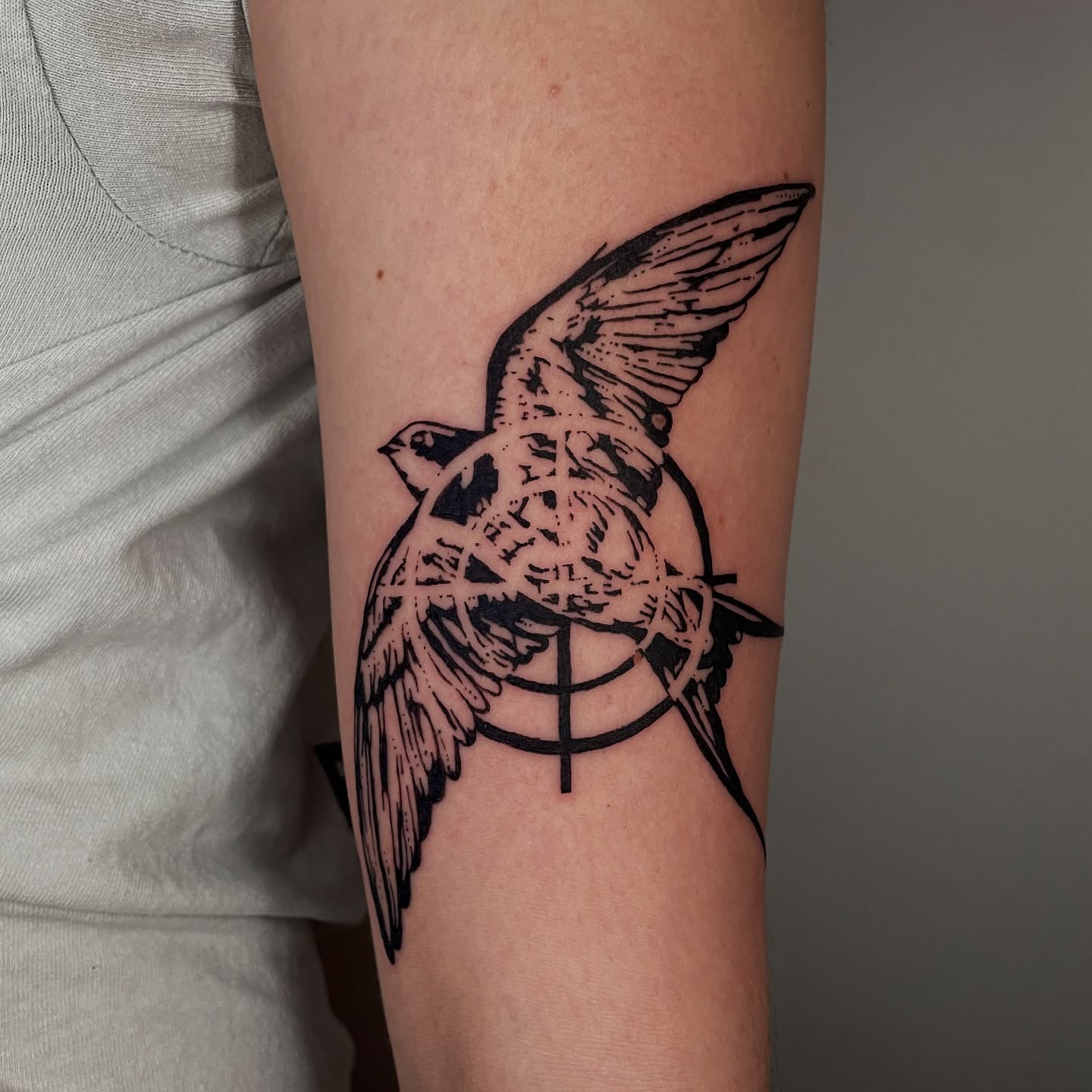Bird black and grey tattoo on the forearm by Sophia Tattoo