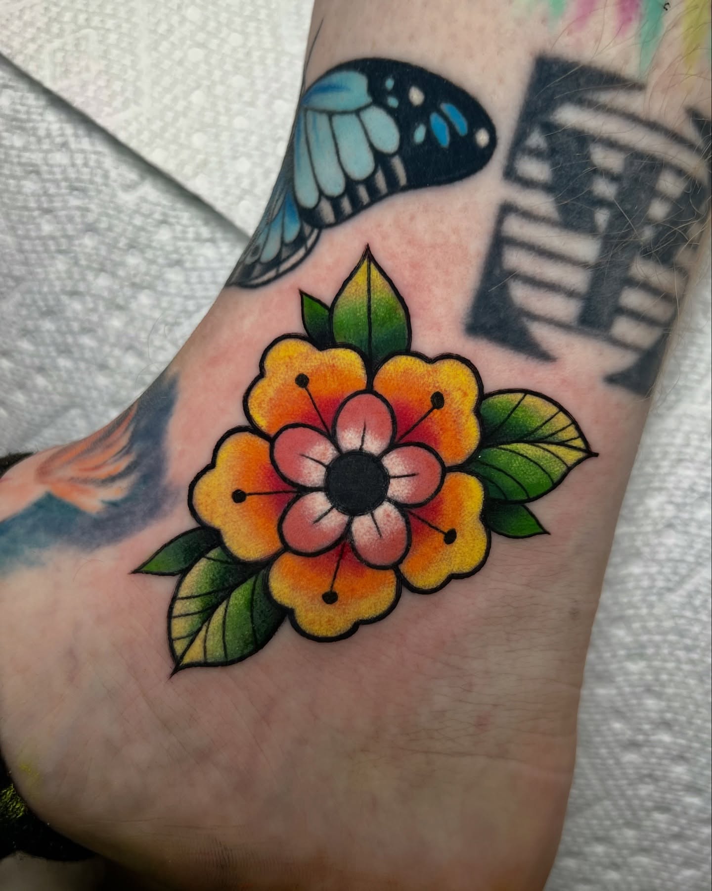 Flower American traditional tattoo on the forearm by Nick Monastra
