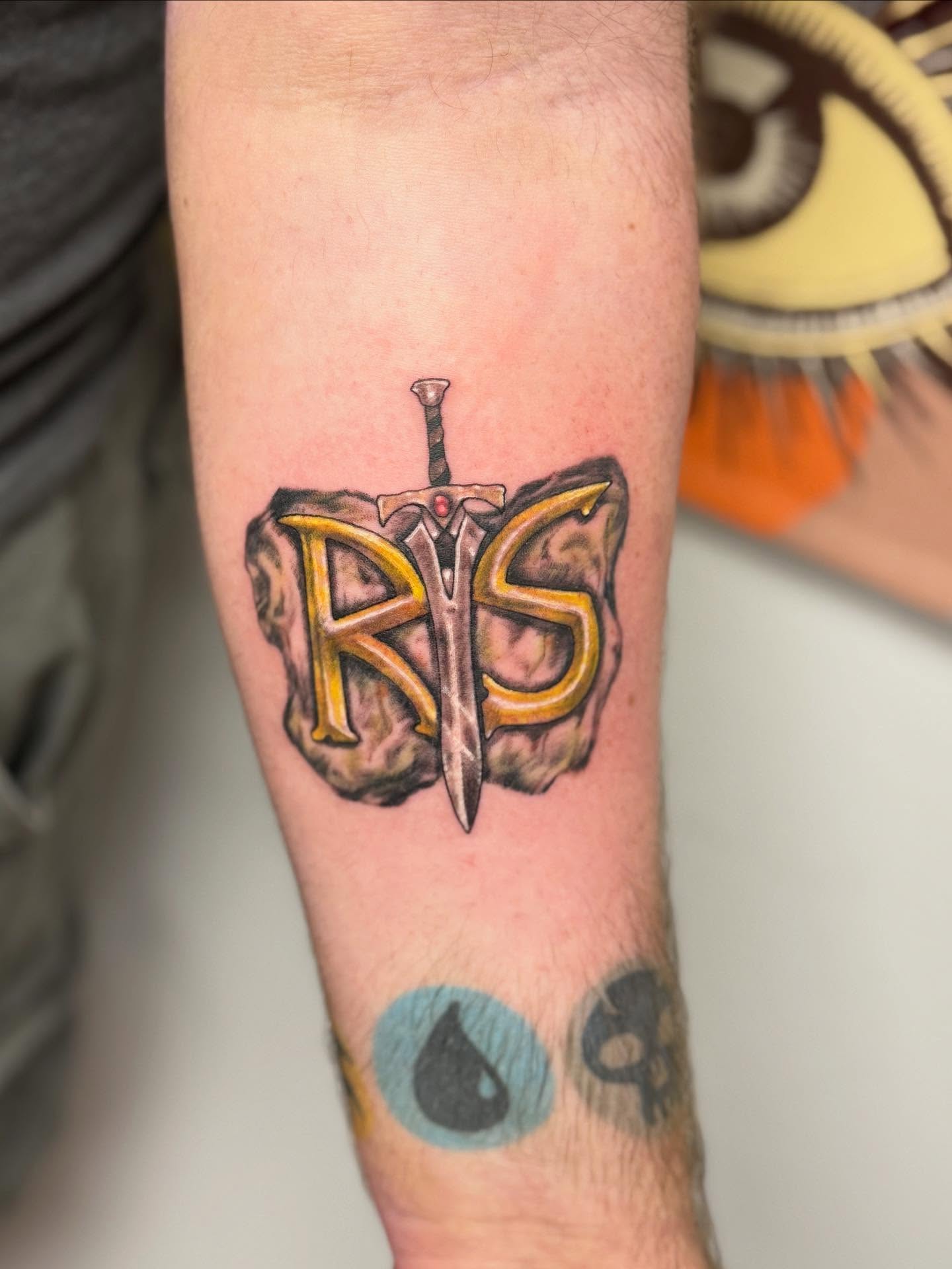 Sword and letters realism tattoo on the forearm by KT