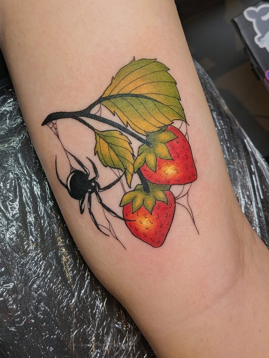 Spider and strawberries neo-traditional tattoo on the forearm by Damon 🥀