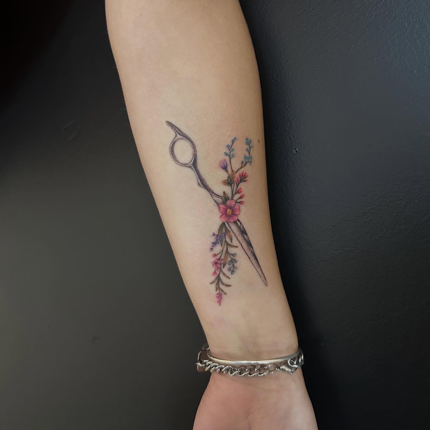 Scissors and flowers new school tattoo on the forearm by Emma