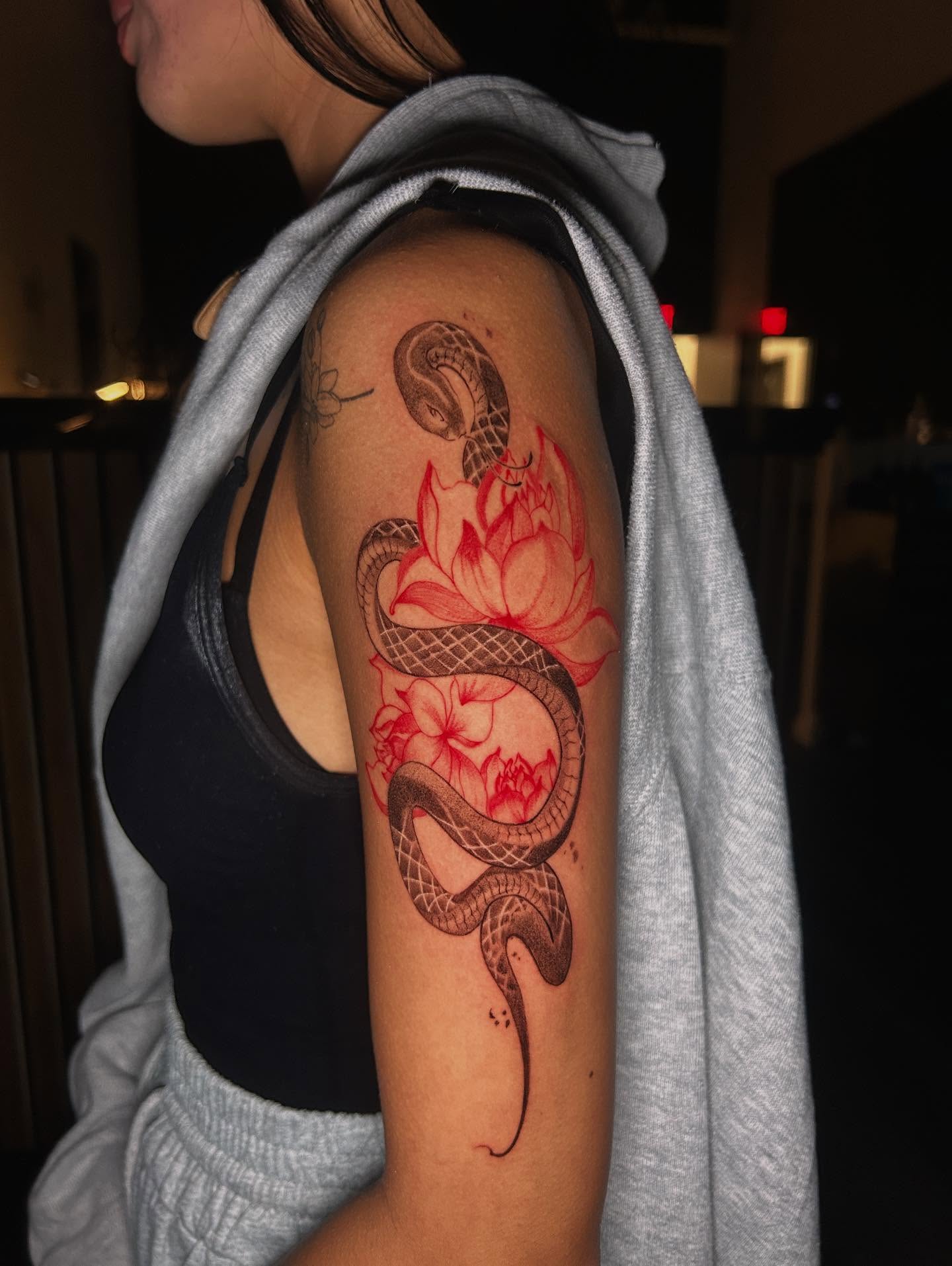Snake and lotus neo-traditional tattoo on the forearm by J
