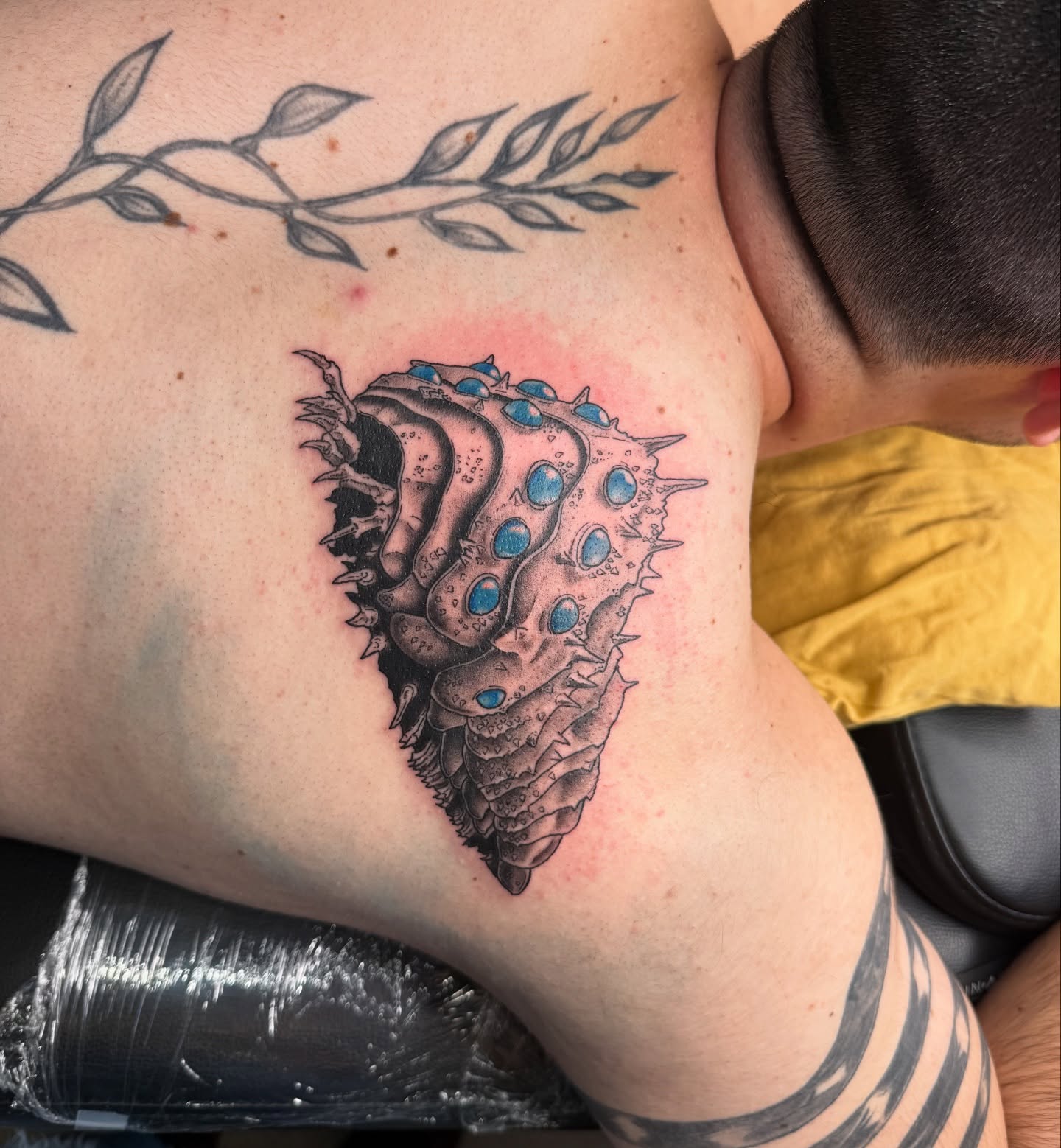Spiky creature black and grey tattoo on the shoulder by Chloe Peters 🦭🦄🏳️‍🌈
