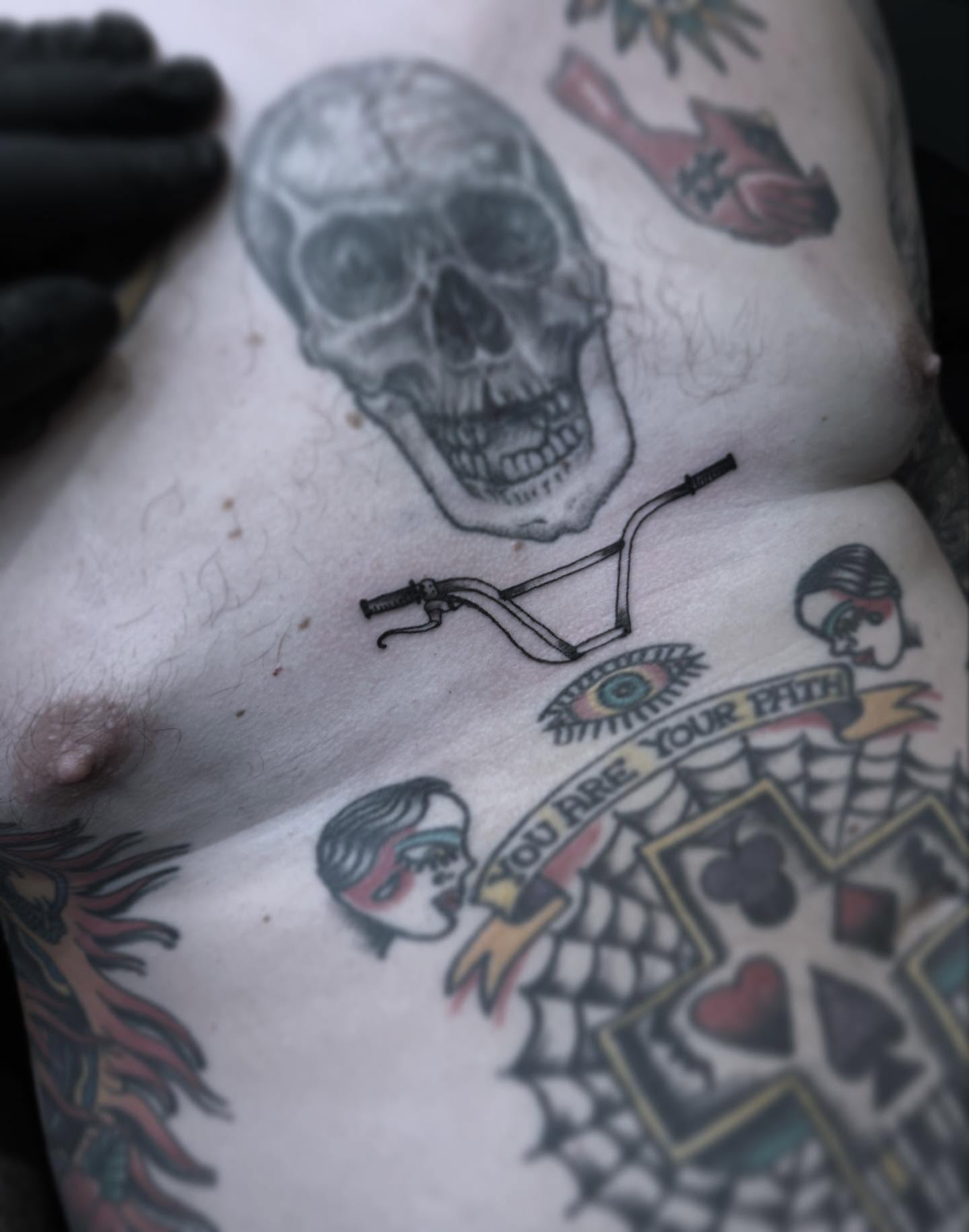 Skull and motorcycle handlebars American traditional tattoo on the chest by Joe Khay, Hackettstown, New Jersey