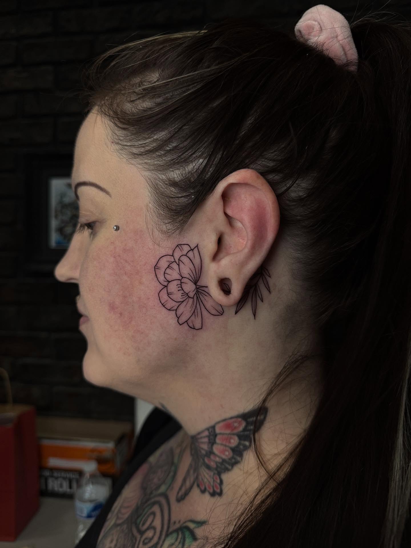 Flower black and grey tattoo on the neck by Demi DiMartino