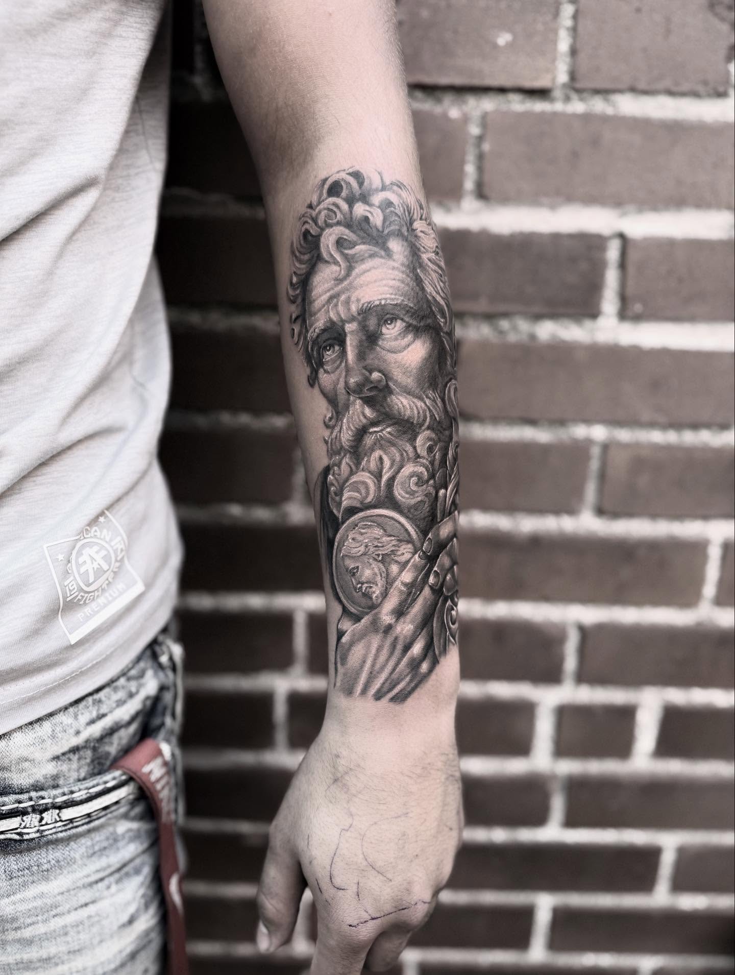 God-like figure realism tattoo on the forearm by Blake Van Vleck