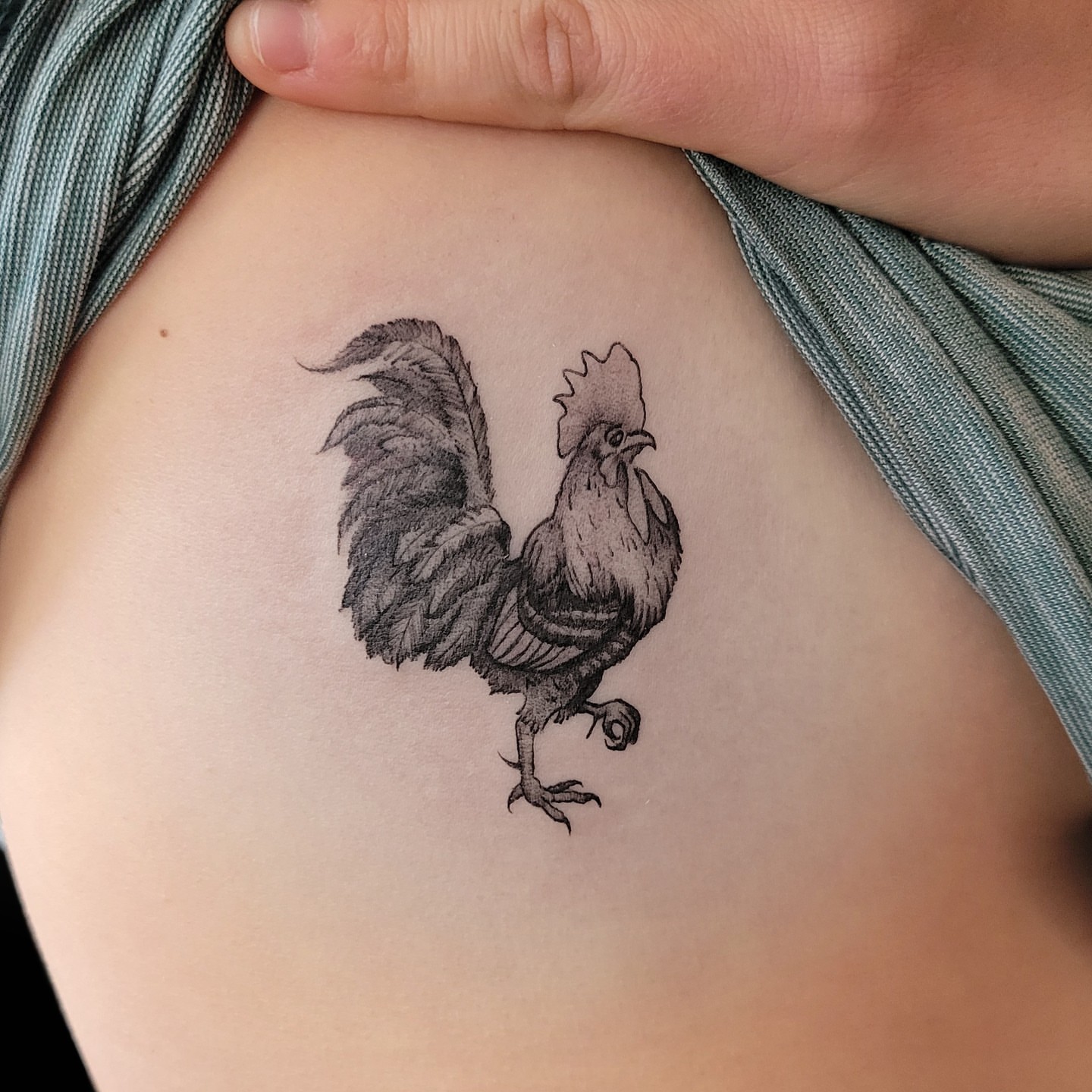 Rooster black and grey tattoo on the ribs by Arick Reese