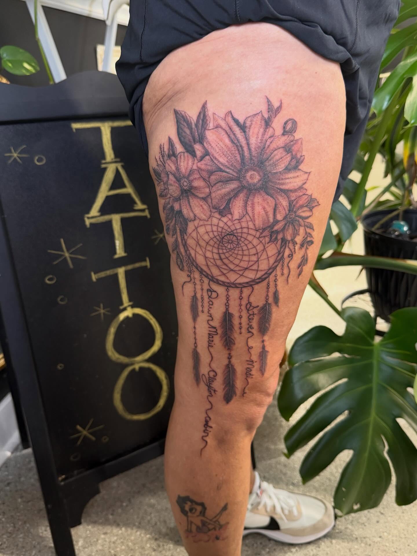 Dreamcatcher with flowers dotwork tattoo on the thigh by Aura Noire