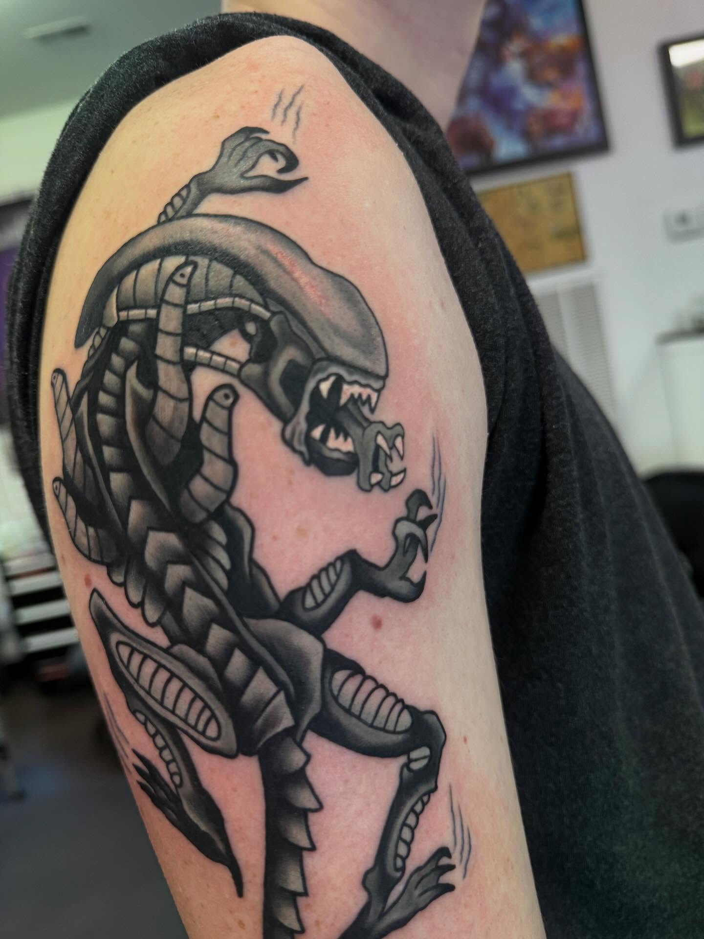 Alien xenomorph black and grey tattoo on the shoulder by Romans