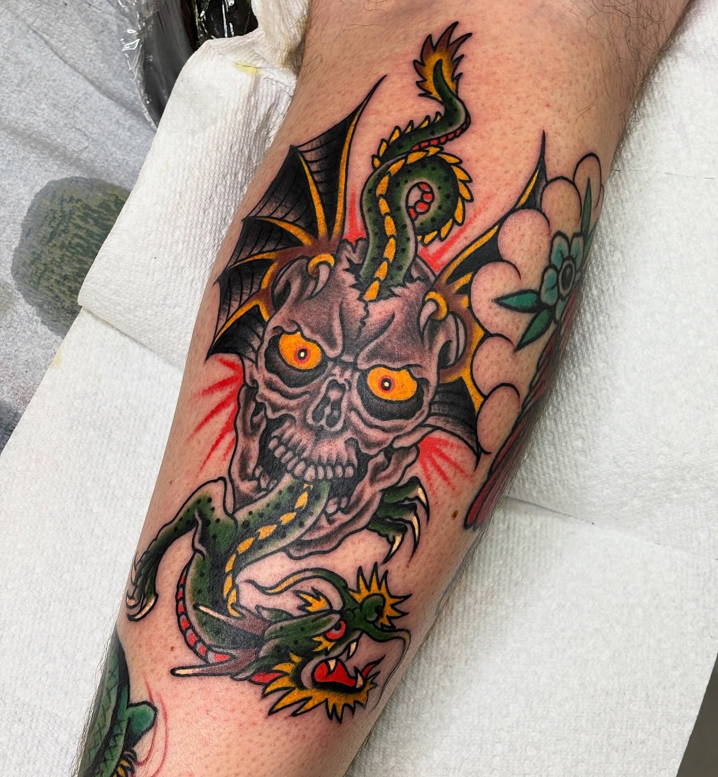 Skull and dragon American traditional tattoo on the forearm by Mike DiCicco