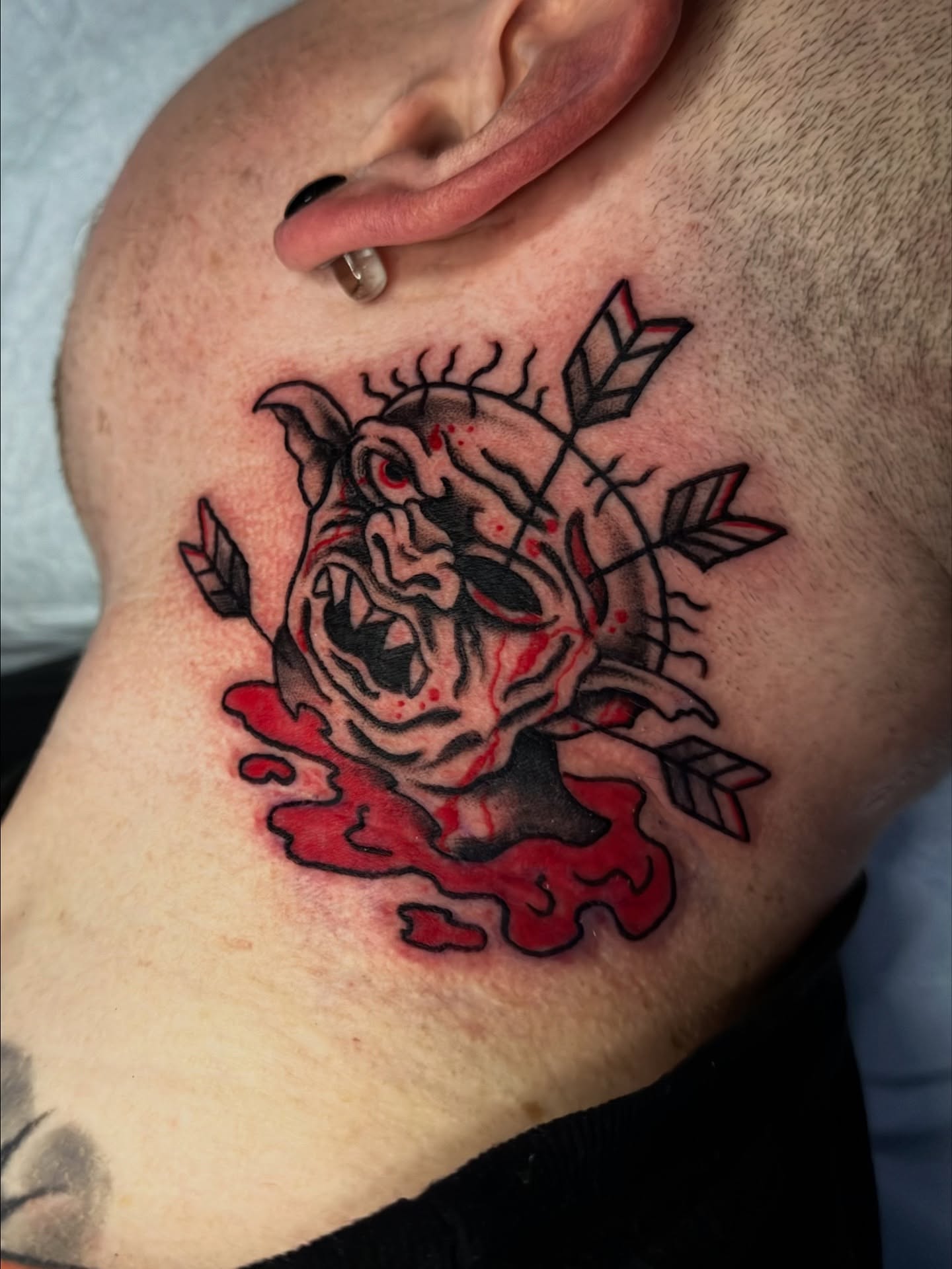 Demon head with arrows American traditional tattoo on the neck by Ash Nicola, Asheville, North Carolina