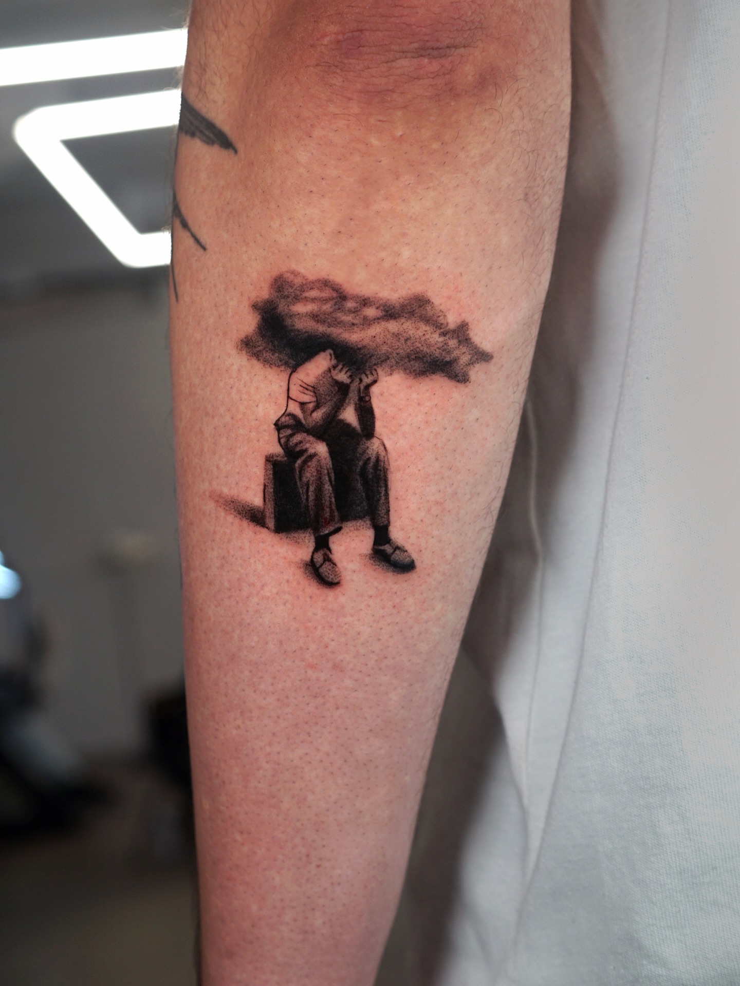 Man under cloud dotwork tattoo on the forearm by Metin Karaatli