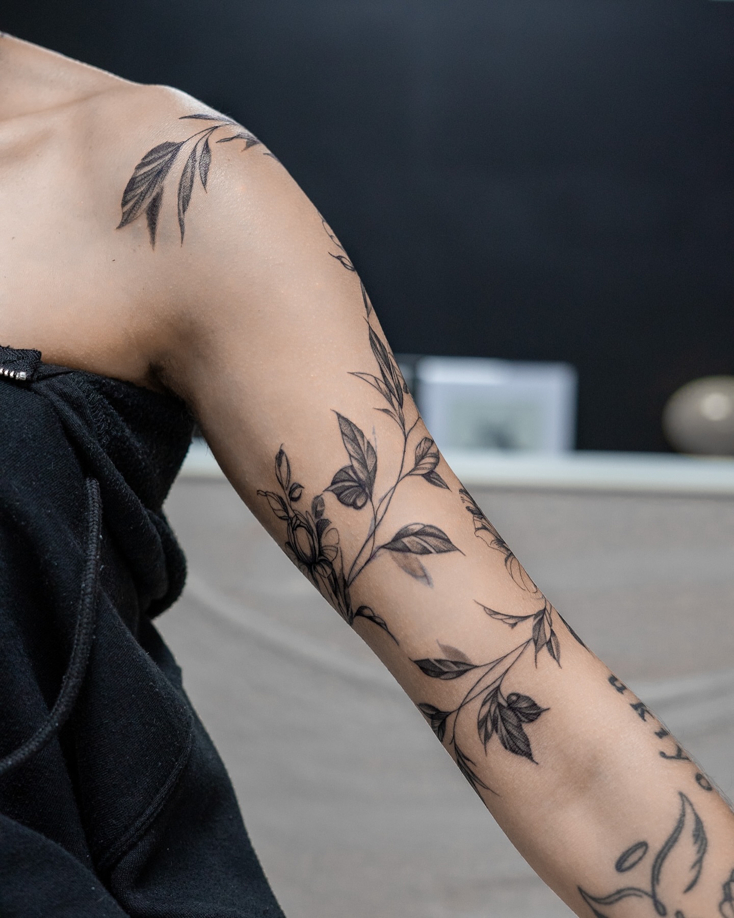 Floral vine black and grey tattoo on the upper arm by The Tattoo Plug