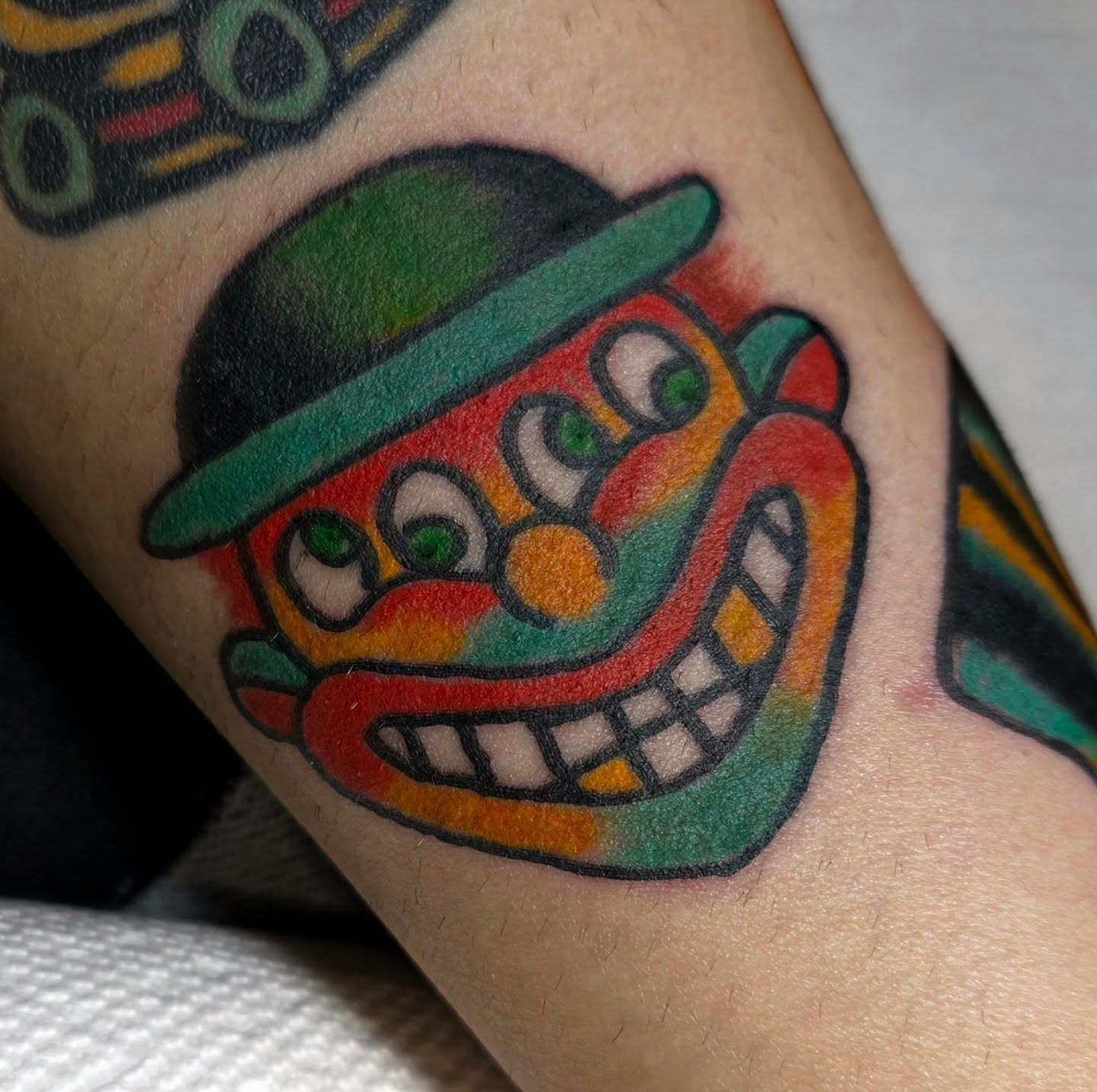 Clown face American traditional tattoo on the forearm by Mitch Braver