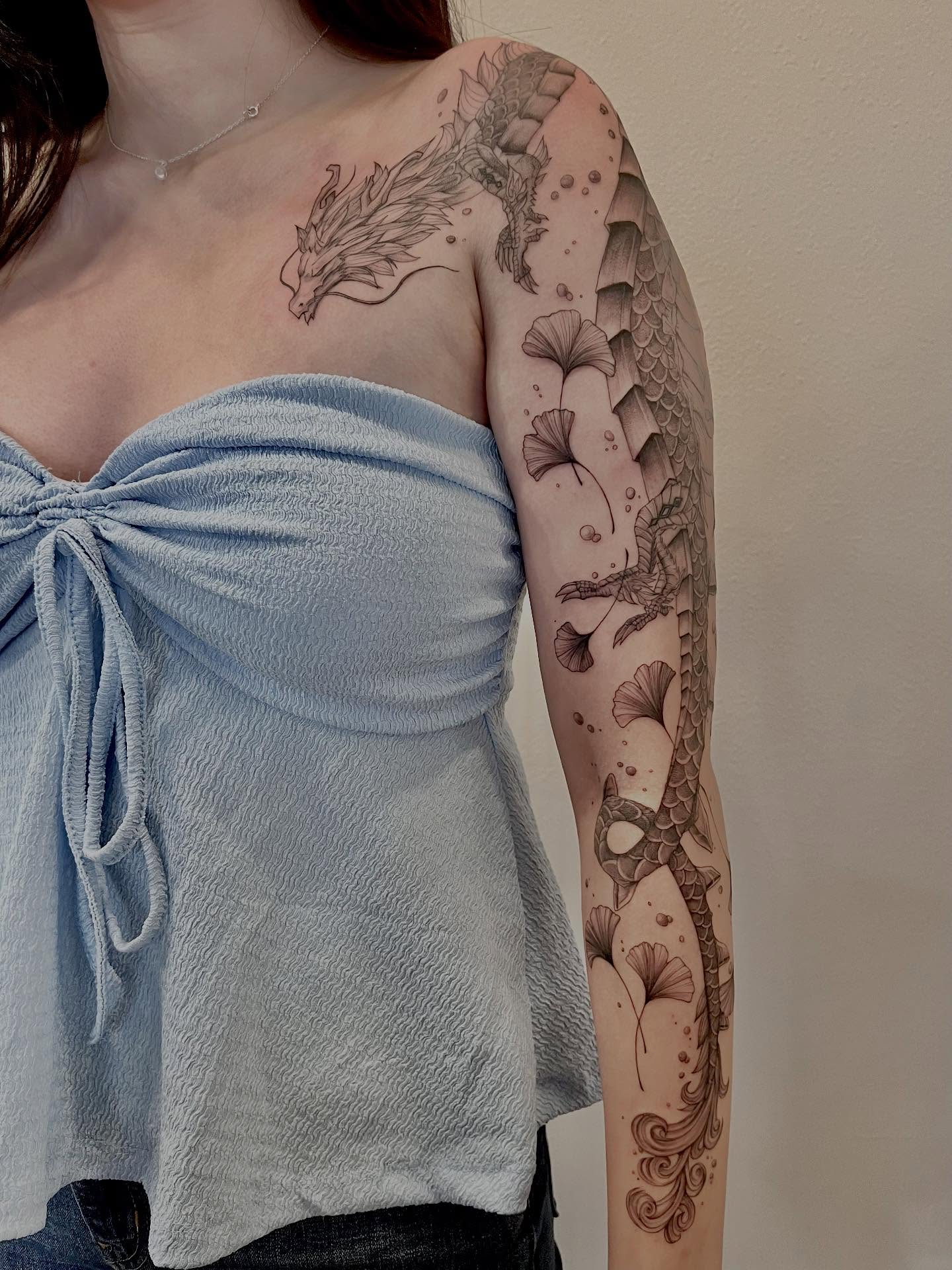 Koi fish and ginkgo leaves realism tattoo on the forearm by Kite.Tattoo_Amber