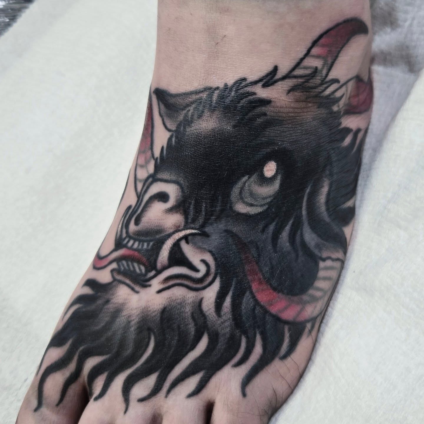 Demon mask American traditional tattoo on the foot by ๐