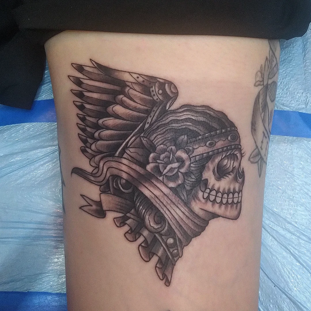 Skull with wings realism tattoo on the thigh by Josh Sroga