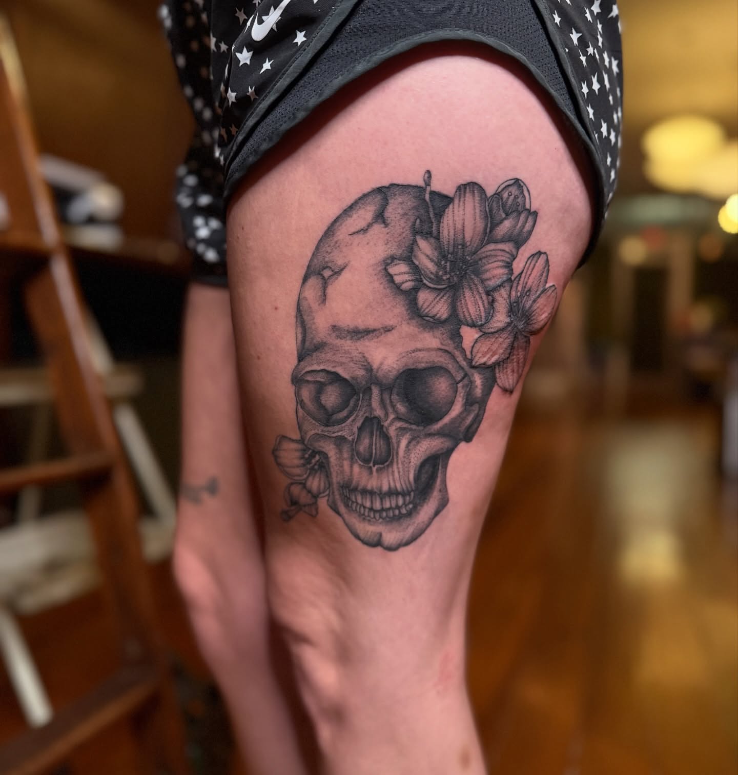 Skull with flowers realism tattoo on the thigh by Jay Kreidler