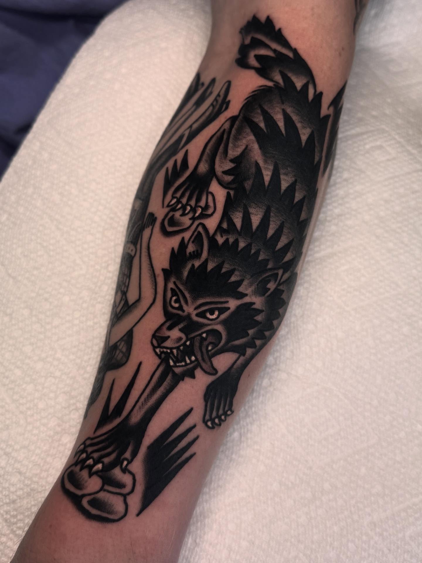 Wolf black and grey tattoo on the forearm by Ryan Engels