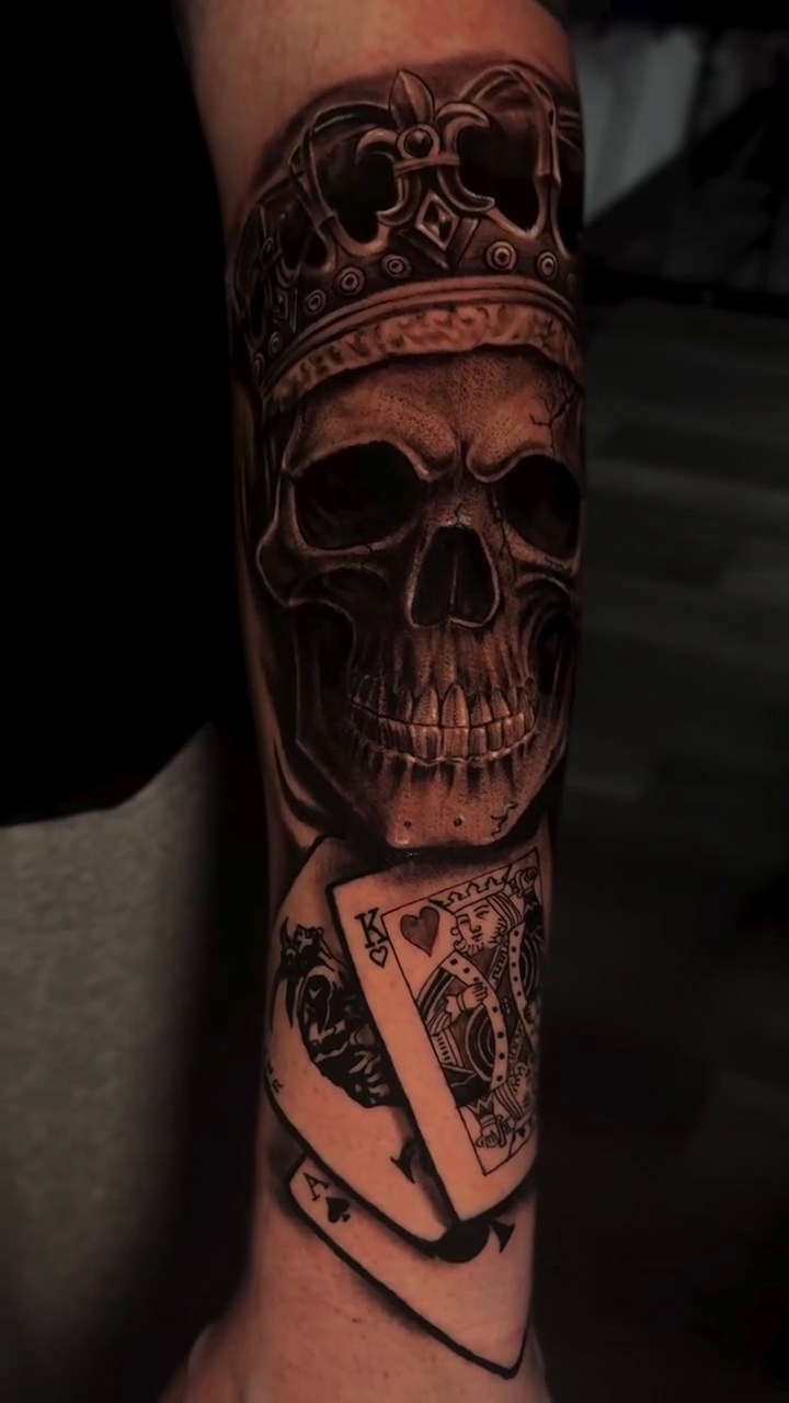 Skull with crown and playing cards realism tattoo by Miguel Garcia