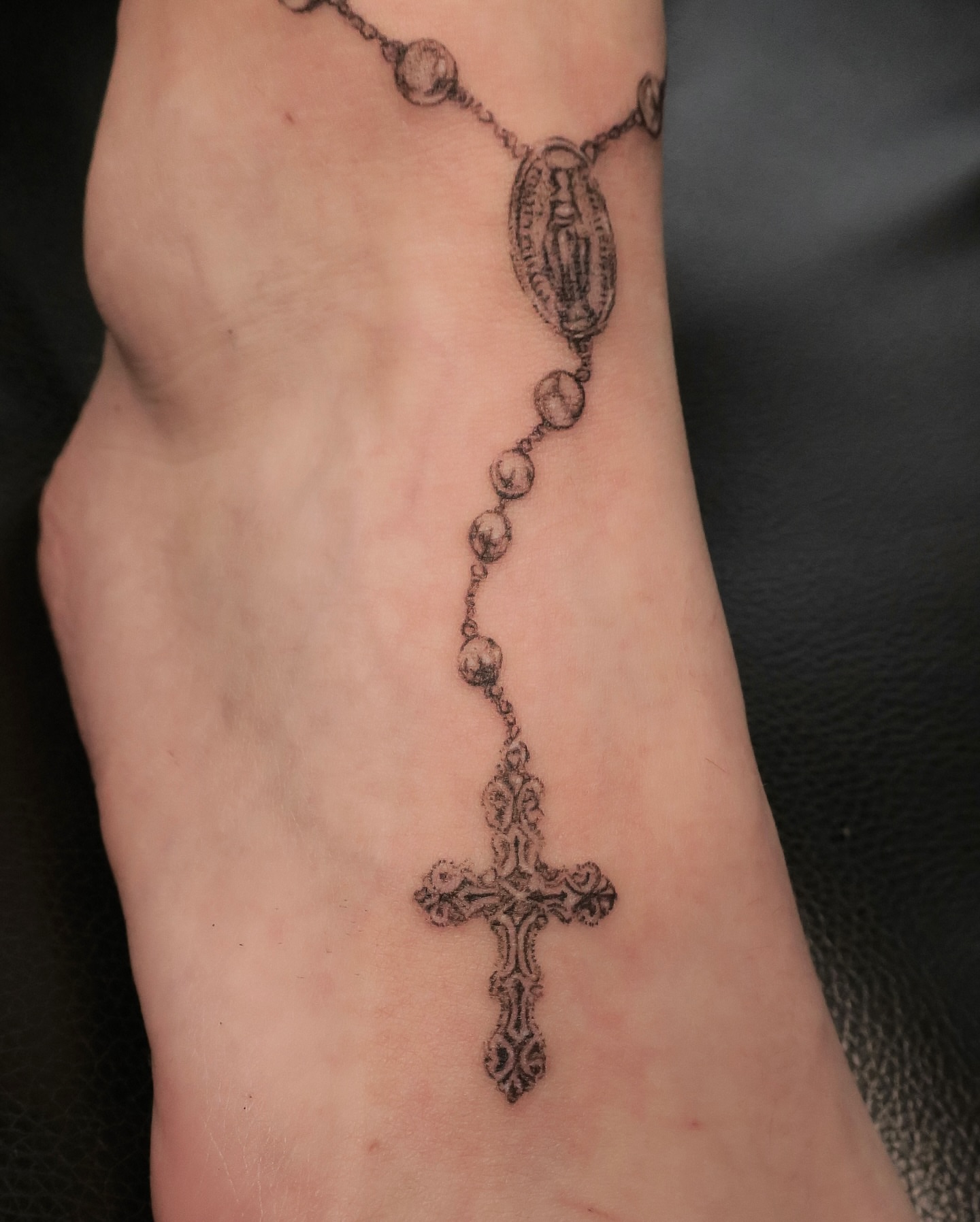 Rosary cross black and grey tattoo on the forearm by Olivia