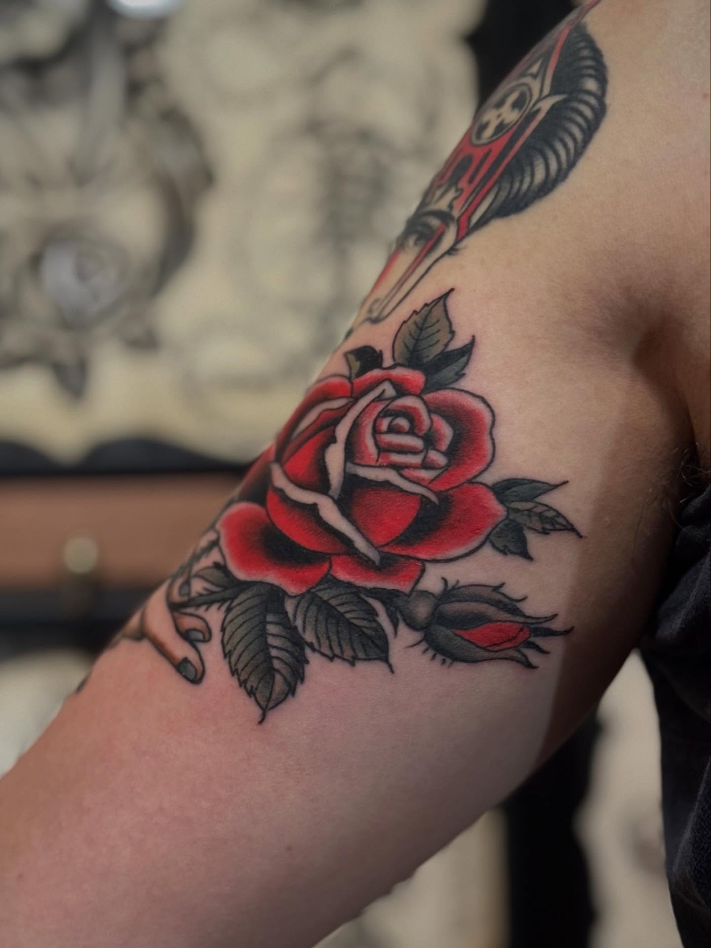 Red rose American traditional tattoo on the forearm by Micah Norman, San Francisco, California
