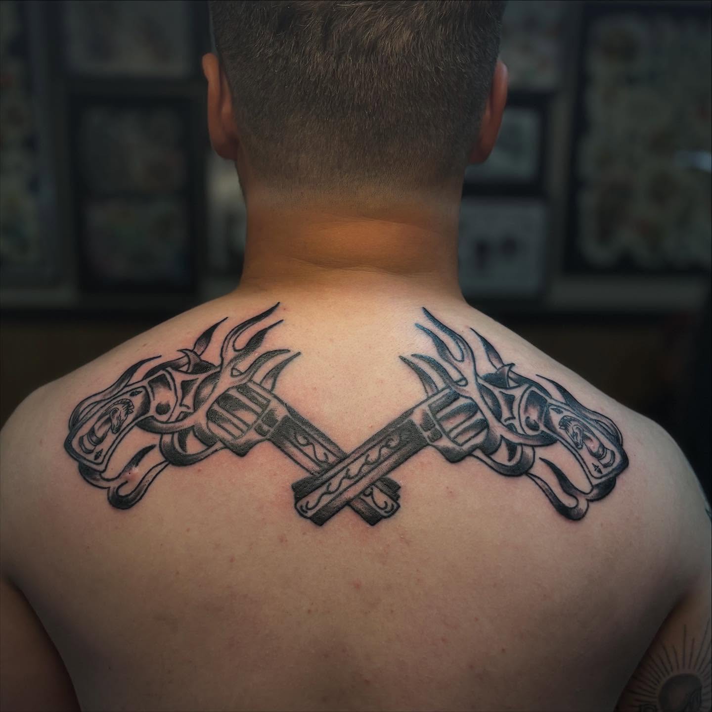 Crossed swords black and grey tattoo on the back by Lauren Deets