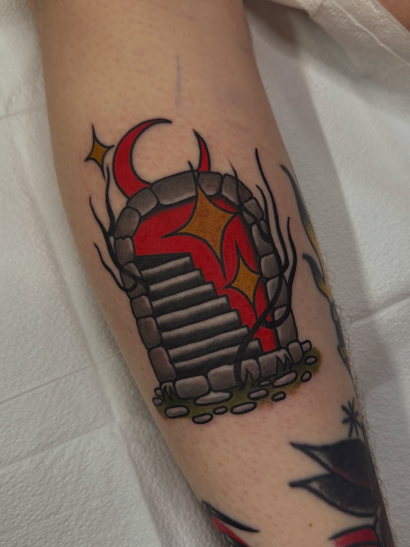 Stone staircase with devil horns American traditional tattoo on the forearm by Cory Craft