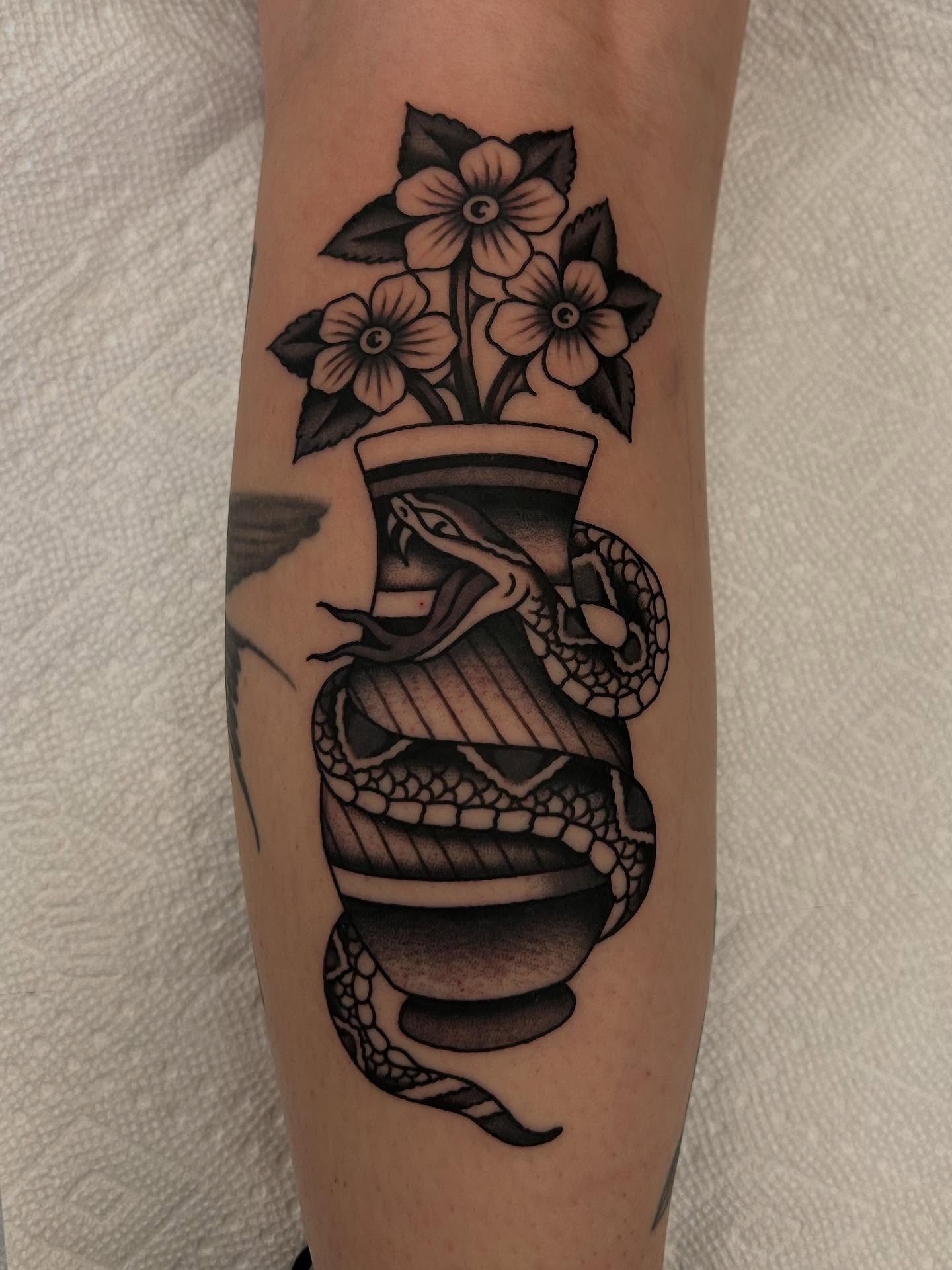 Snake and flowers American traditional tattoo on the forearm by Christian Lasyone