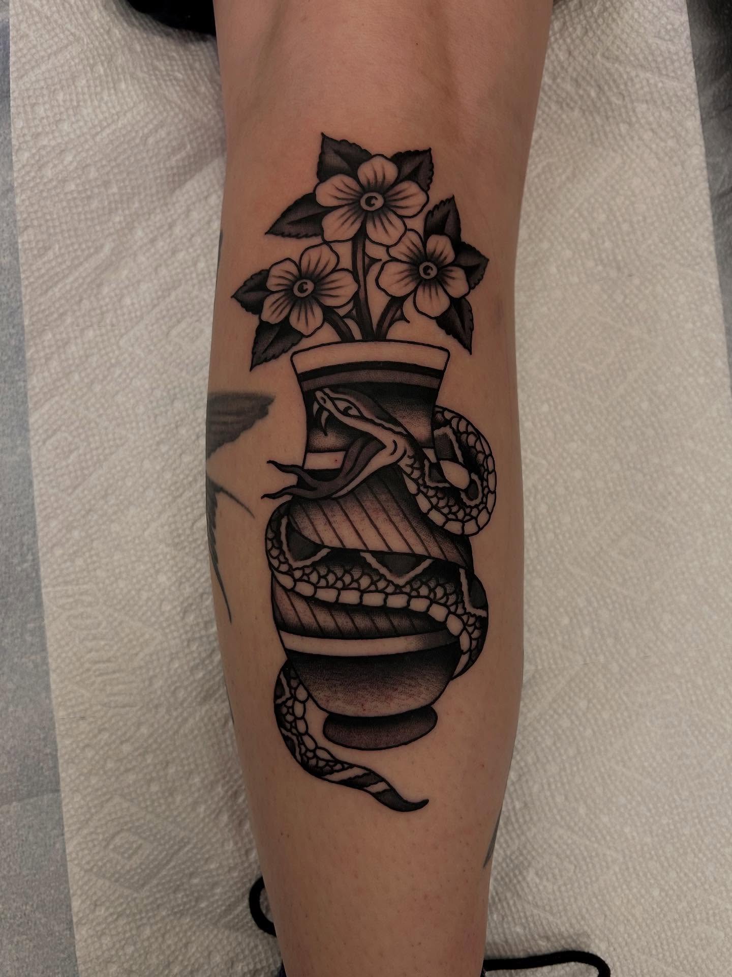 Snake and flowers black and grey tattoo on the forearm by Christian Lasyone