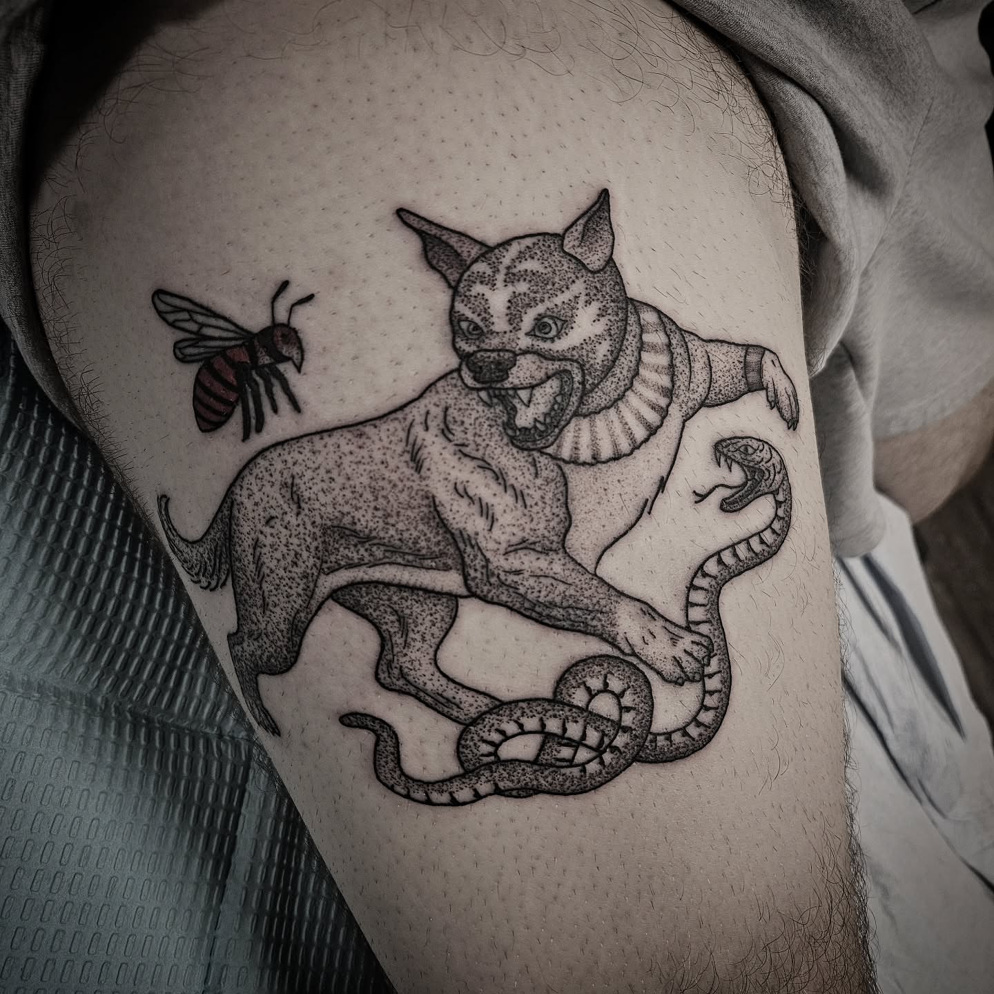 Cat and snake dotwork tattoo on the thigh by Kirk George