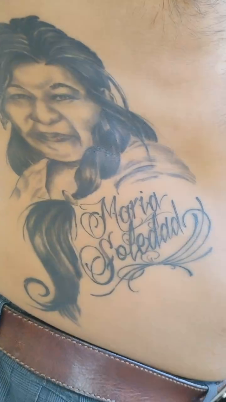 Portrait of a woman with script tattoo on the upper arm by Alfredo Sosa