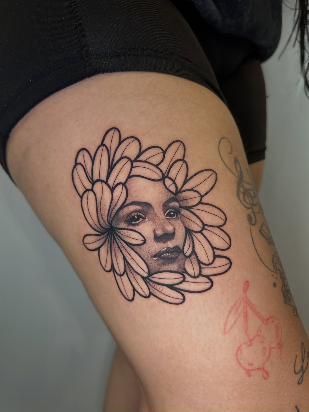 Woman's face surrounded by petals sketch tattoo on the thigh by 𝘋𝘪𝘢𝘯𝘯𝘢