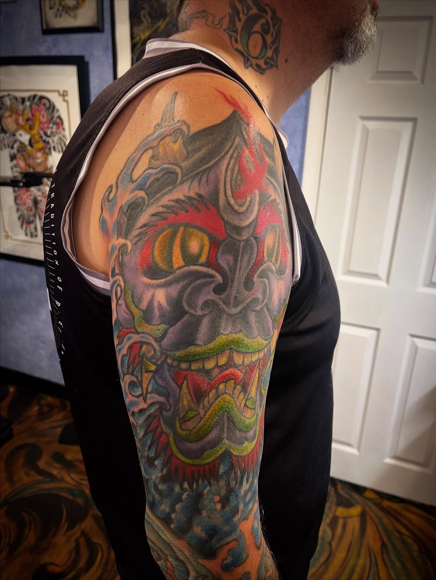 Demon face japanese irezumi tattoo on the upper arm by Don Juan