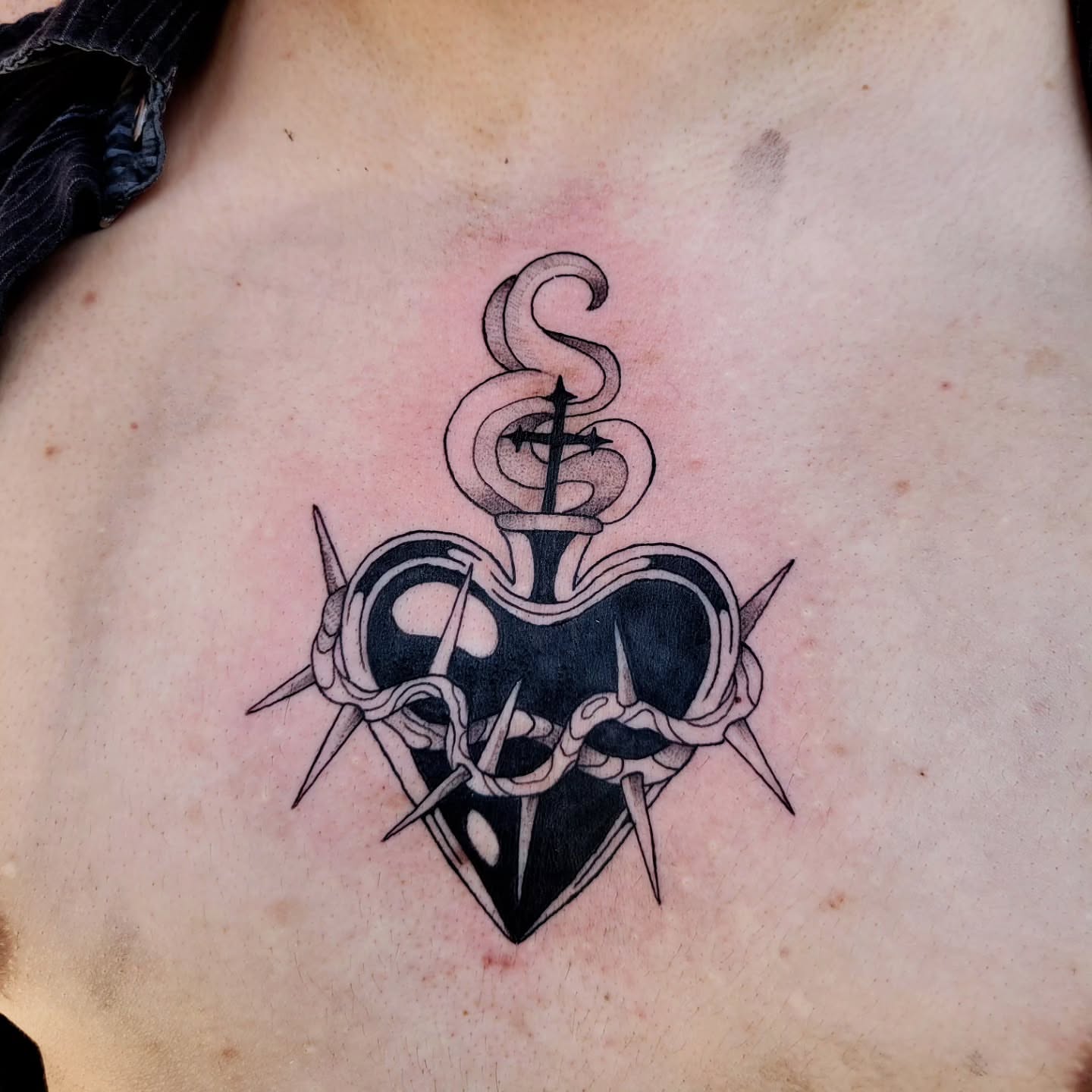 Heart with crown and cross black and grey tattoo on the chest by Taylor