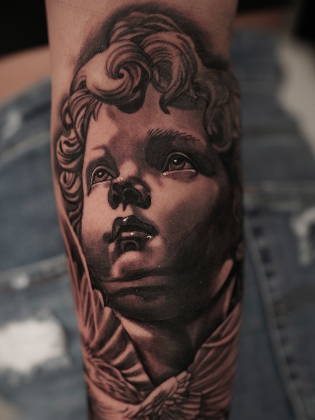 Child's face realism tattoo on the forearm by Travis