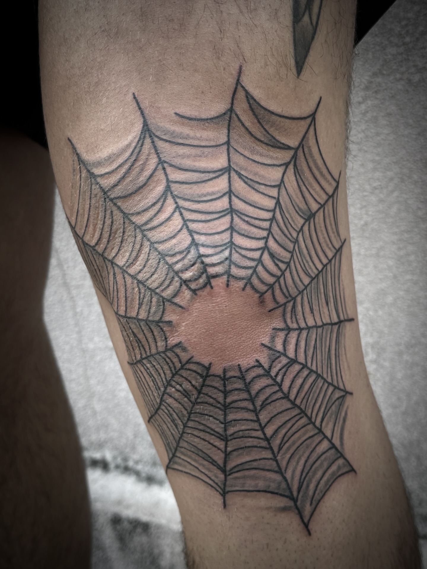 Spider web black and grey tattoo on the forearm by Chris Blanchard