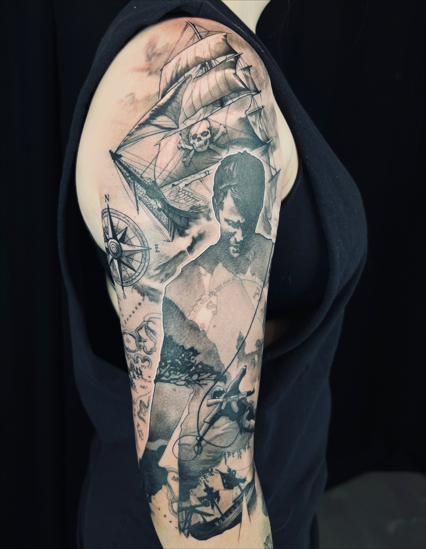 Pirate ship and man realism tattoo on the upper arm by Apologies tattoo studios.