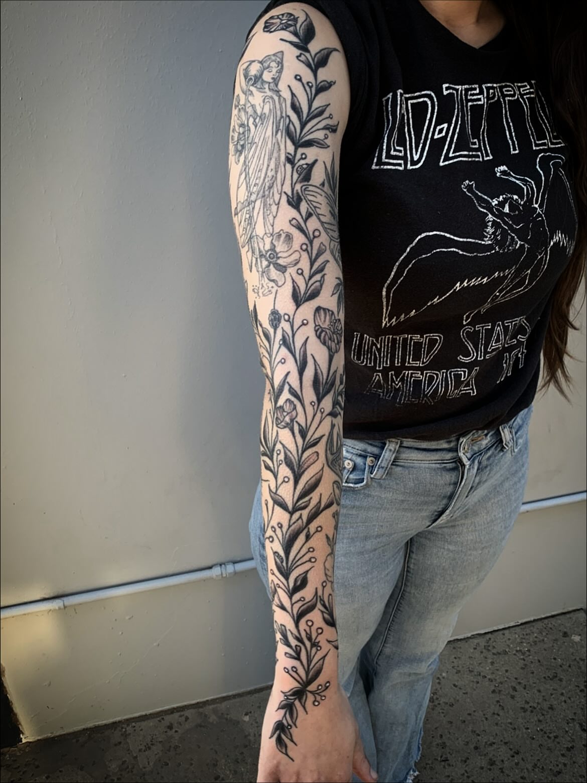 Floral and botanical fine line tattoo on the upper arm by Sean Gallagher