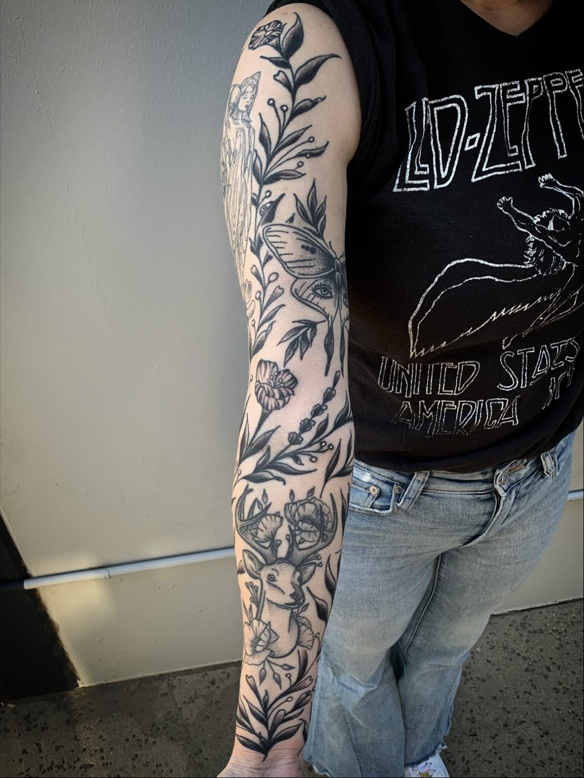 Botanical and animal motifs black and grey tattoo on the forearm by Sean Gallagher