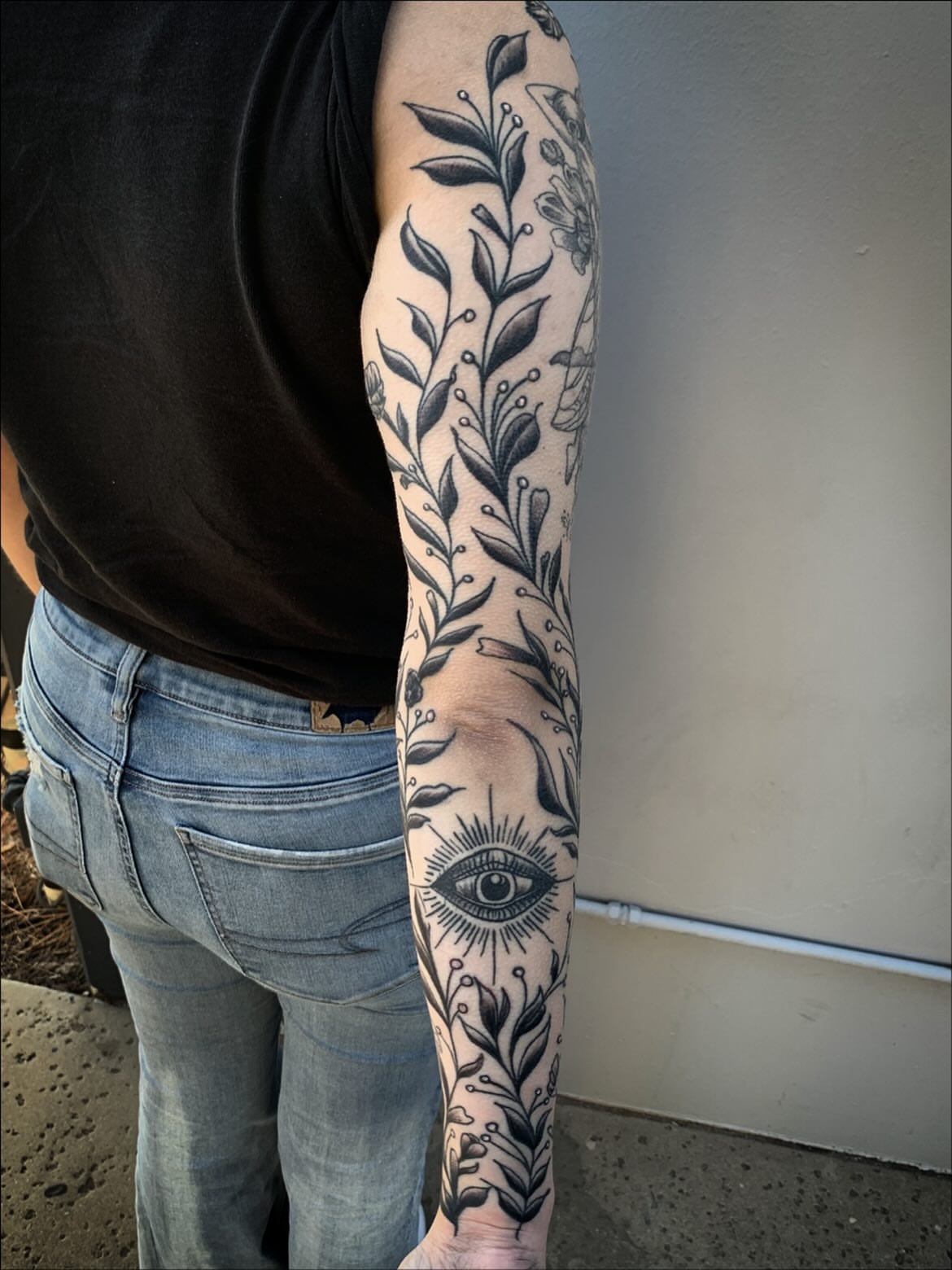 Floral vine with eye ornamental tattoo on the forearm by Sean Gallagher